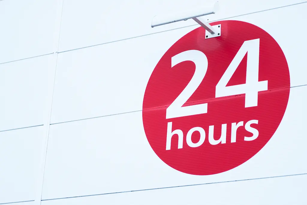 Red and white circular graphic sign reading "24 Hours."